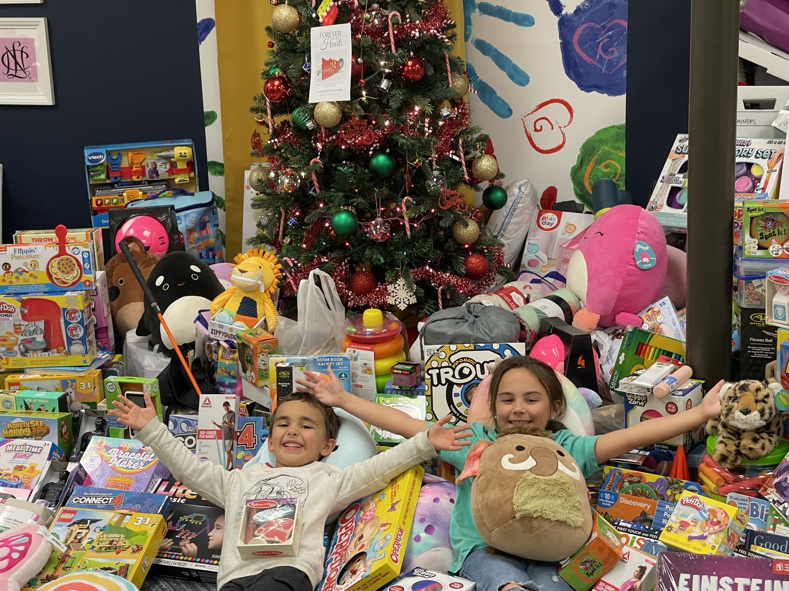Original photograph of children celebrating in front of the toy donations